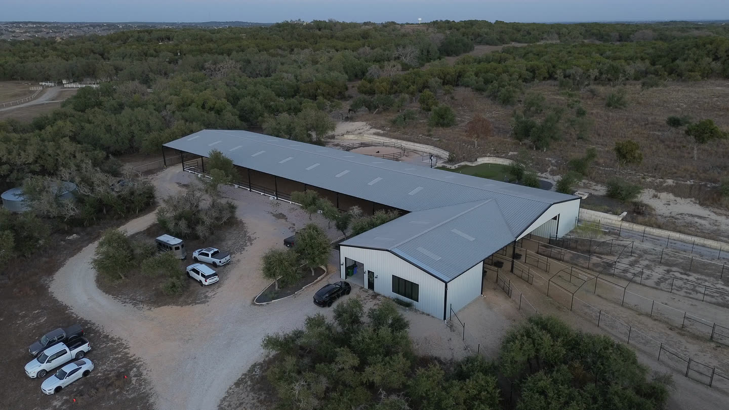The L-shaped barn and its drive, seen from the air in the evening