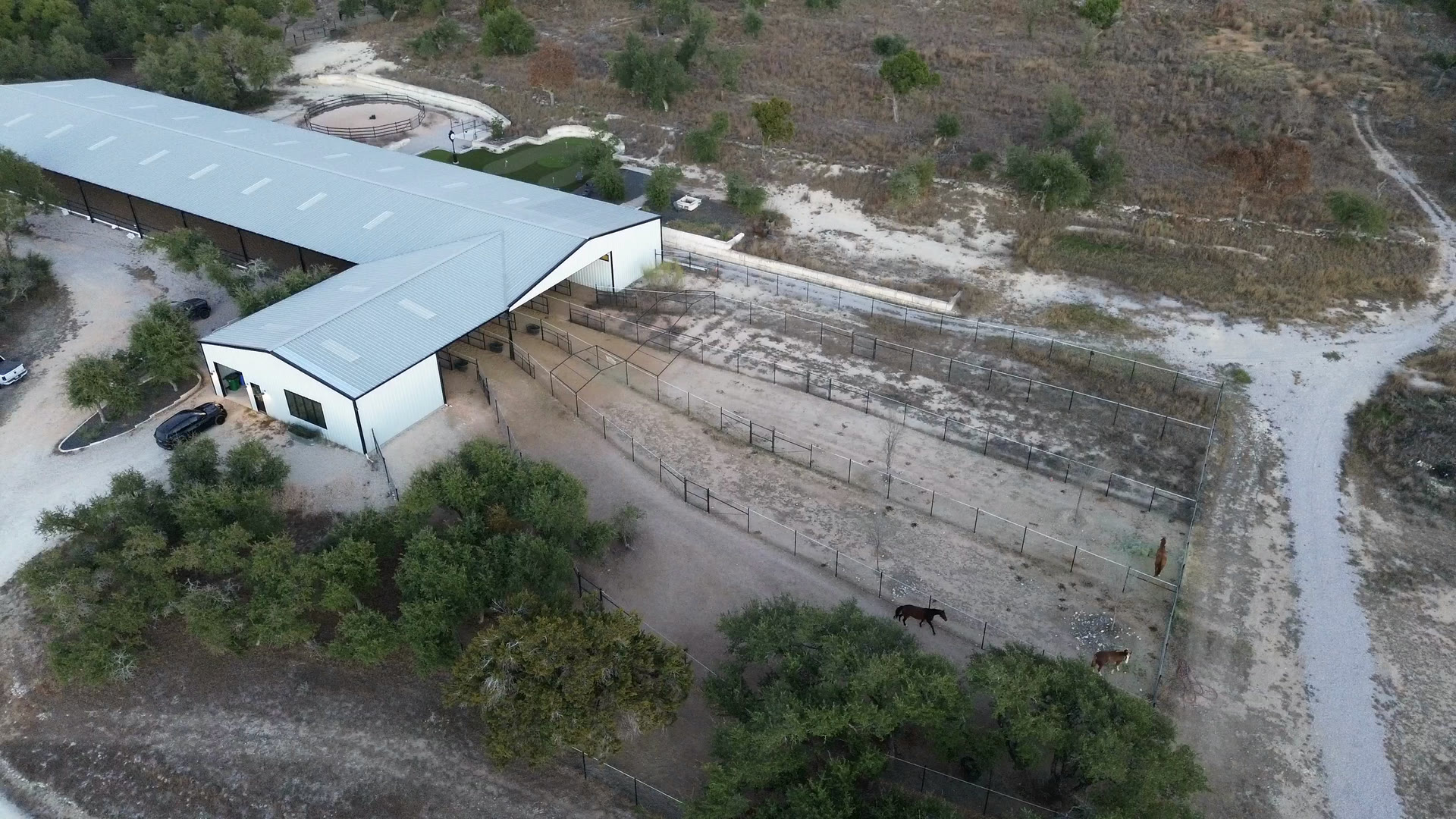 Paddocks running out from behind the barn, seen from the air